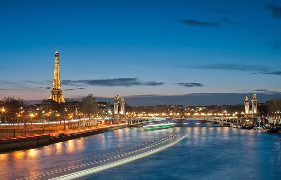 Eiffel Tower and Pont Alexandre III illuminated at night with the Seine in the foreground