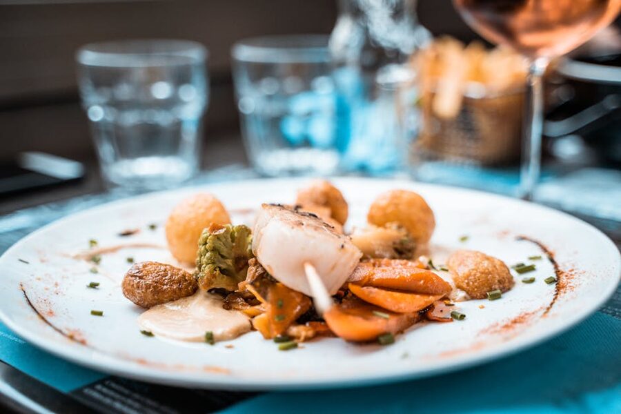 Beautifully plated scallop dish with vegetables in a French restaurant