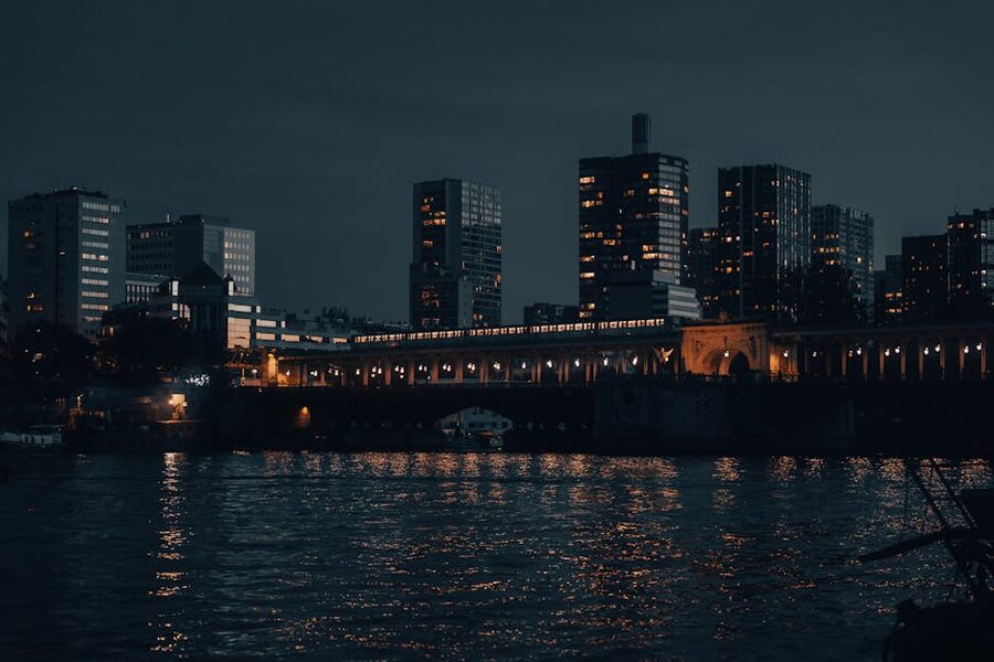 Paris skyline at night with illuminated buildings reflected on the Seine