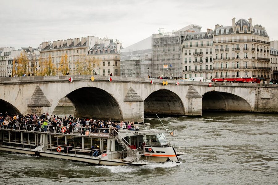 Tourists on a Seine River cruise boat with views of Parisian architecture and bridges