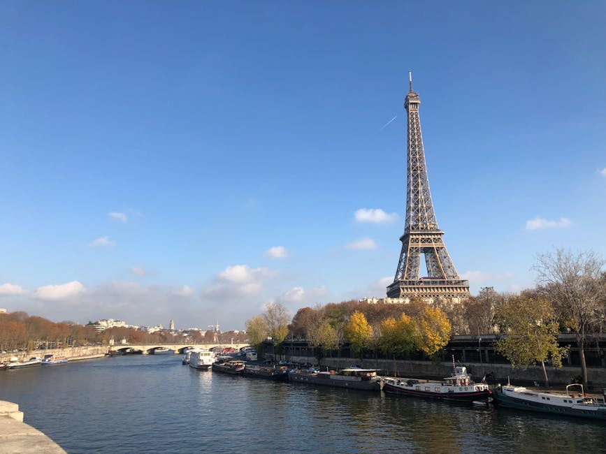 Eiffel Tower seen from the Seine riverbank with cruise boats