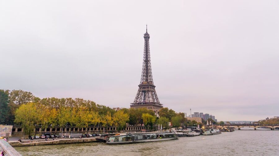 Eiffel Tower over the Seine with autumn-coloured trees lining the riverbank