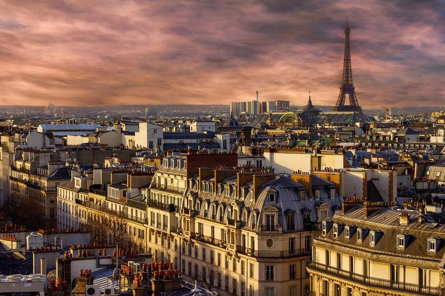 Eiffel Tower lit up at night above the Seine River in Paris