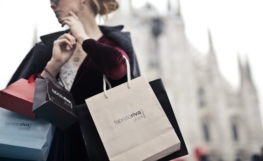 Stylish woman holding designer shopping bags in Milan