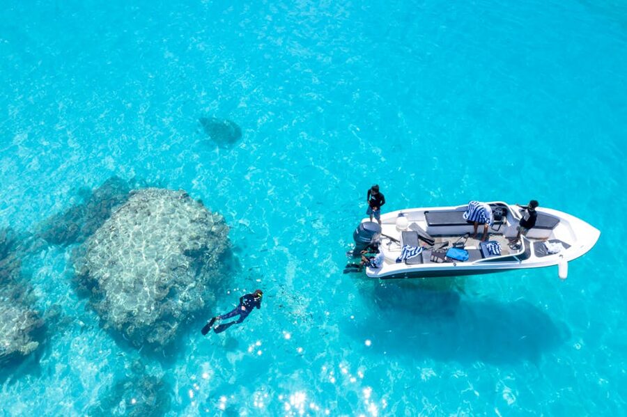 Snorkelers in clear water near a boat