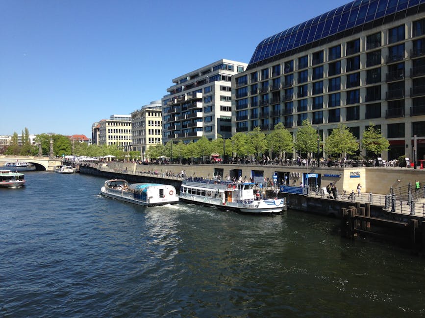 Sunny day on the Spree River with tour boats and modern Berlin buildings