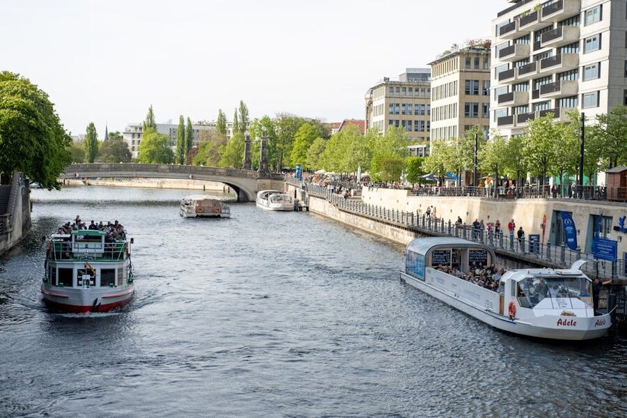 Tour boats cruising along the Spree past Berlin urban skyline