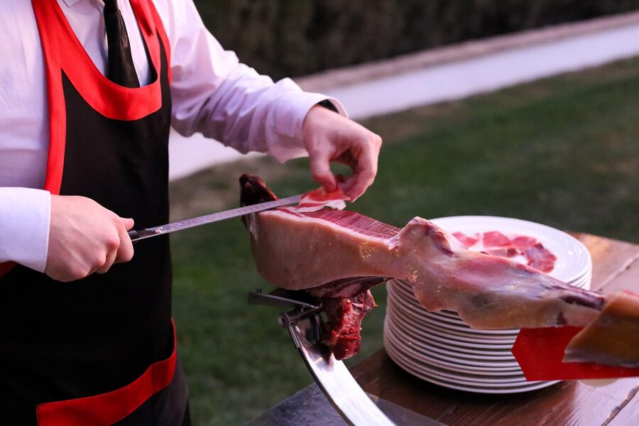 Jamon cutter slicing iberian ham at a tapas bar