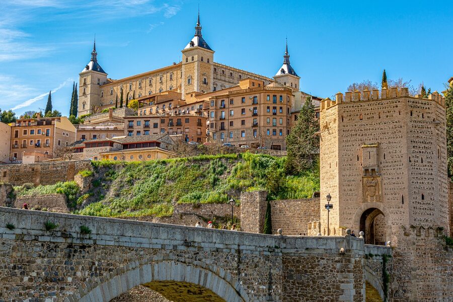 Alcázar of Toledo above a bridge over the Tagus river at sunset