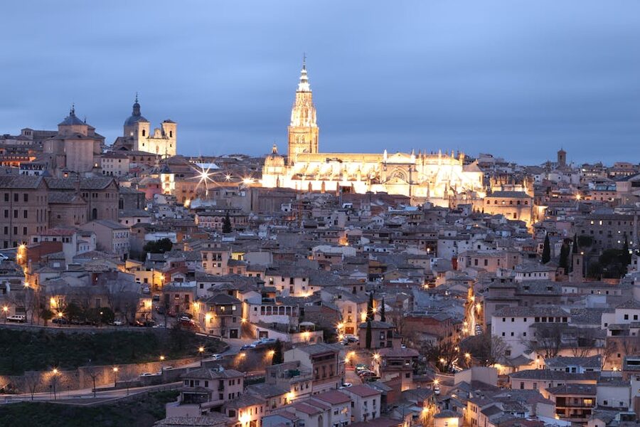 Toledo Cathedral spire illuminated at night above the medieval old town