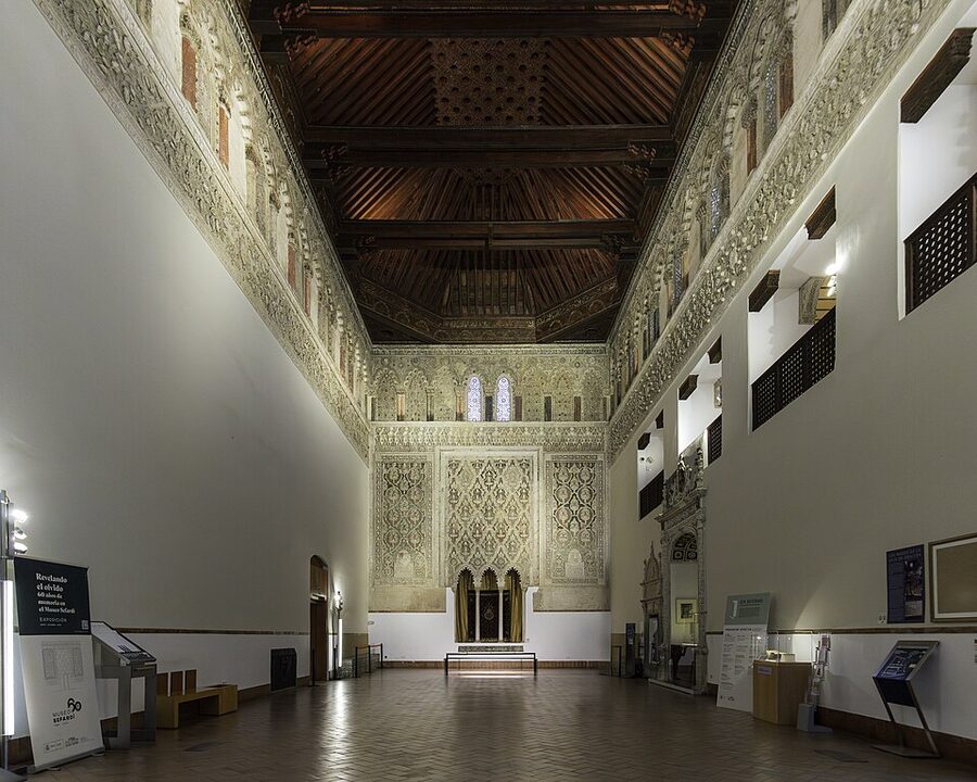 Prayer hall of the Sinagoga del Tránsito in Toledo with carved stucco walls and inscribed frieze