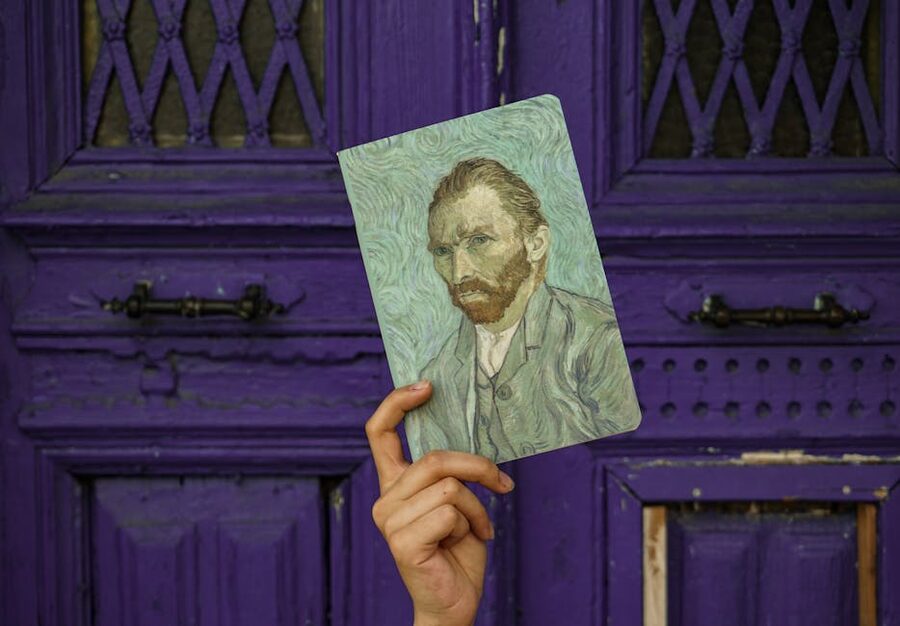 A hand holds a Van Gogh self-portrait reproduction
