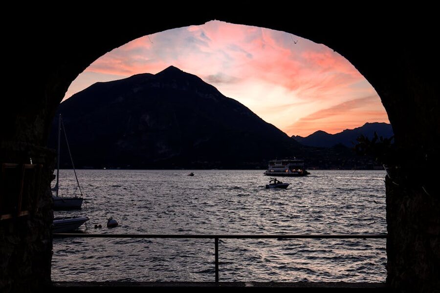Sunset over Lake Como Varenna with boats and mountains