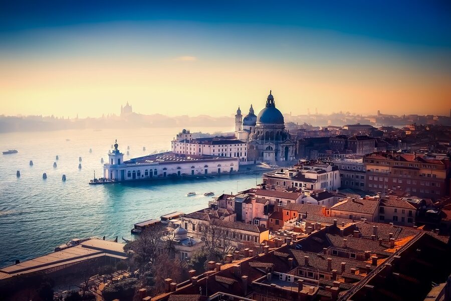 Soft morning light on a Venetian canal with reflections of pastel buildings