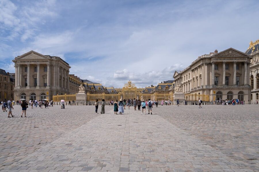Tourists walking through Versailles courtyard