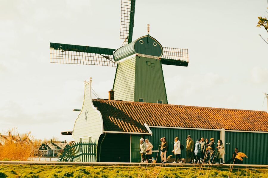 Tourists exploring a Zaanse Schans windmill on a sunny day
